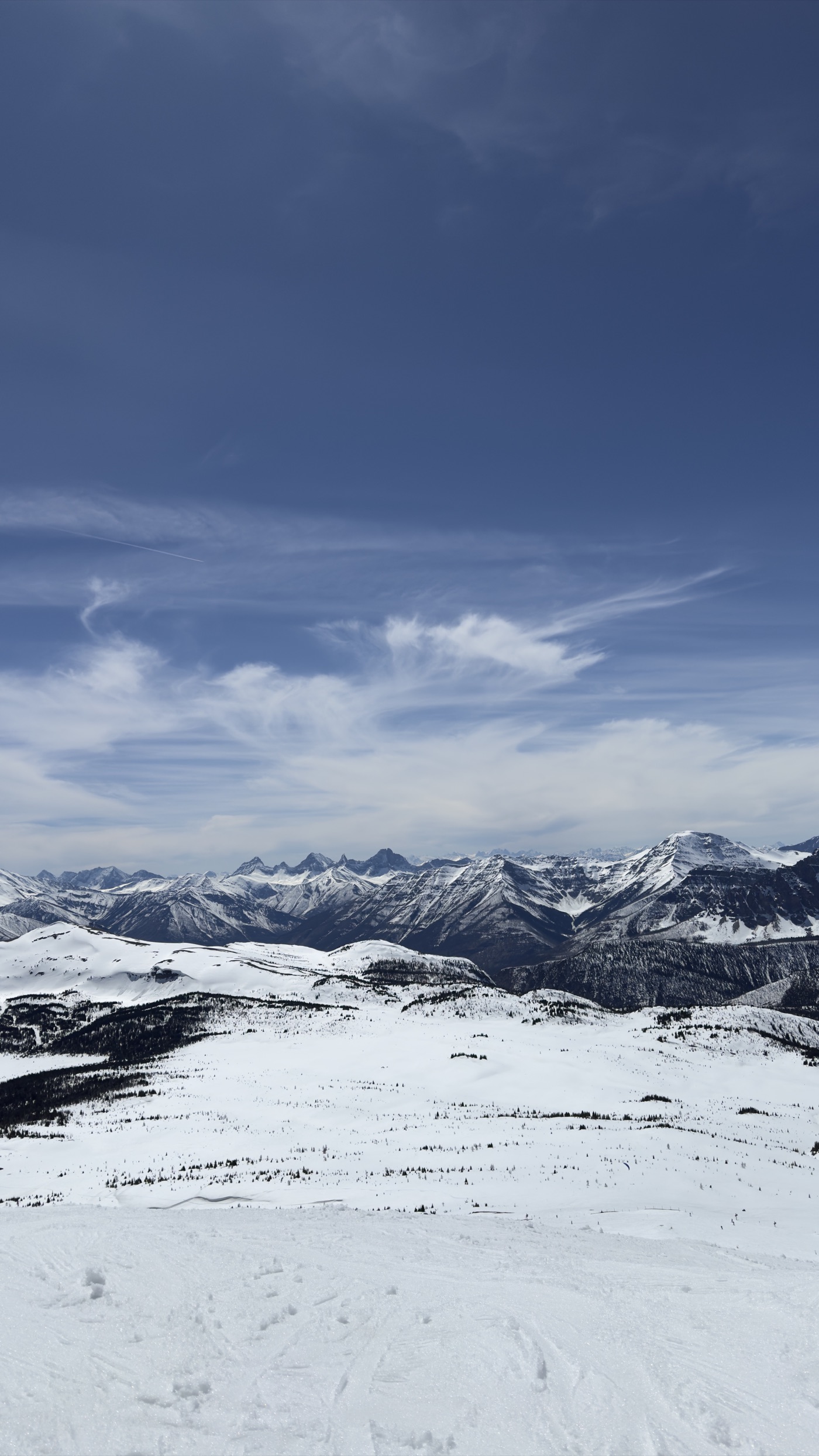 A snow-covered mountain range under a deep blue sky